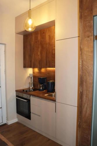 a kitchen with white cabinets and a stove top oven at Superior Petit Studio in Mytilini