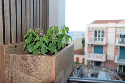 a plant in a wooden planter on a balcony at Superior Petit Studio in Mytilini