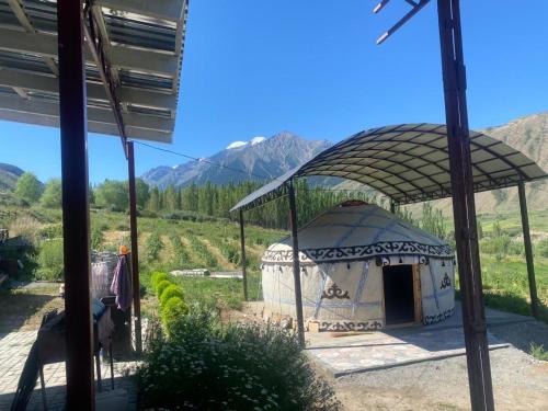 a yurt with a roof with mountains in the background at Taldy-Bulak Guest House in Barskoon