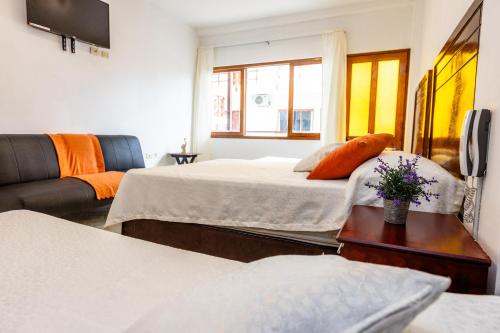 a hotel room with two beds and a couch at Costa Beach in Zorritos