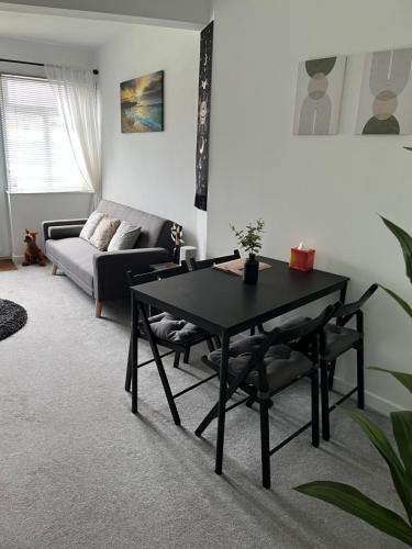 a living room with a black table and a couch at Cozy one bedroom apartment in Surbiton