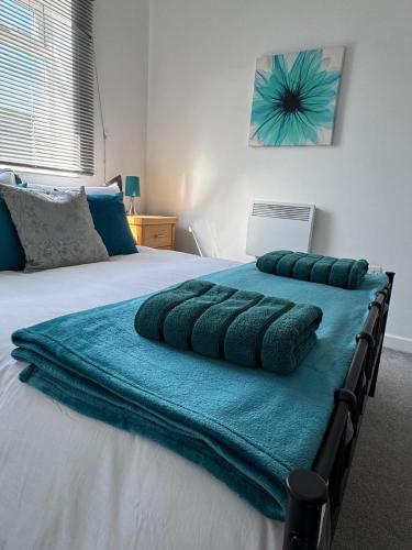 a bed with four pillows on top of it at Cozy one bedroom apartment in Surbiton