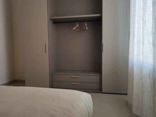 a bedroom with a closet with a bed and a window at Soggiorno in villa - apt with kitchen and terrace in Gambellara