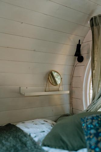 a small bedroom with a mirror and a bed at Beczki Pod Lasem in Trzemeśnia