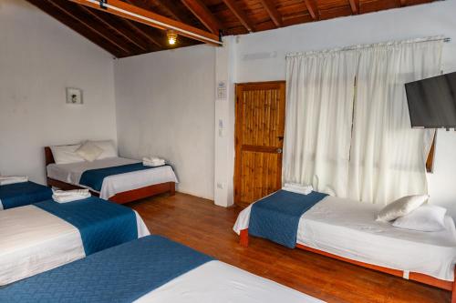 a bedroom with two beds and a television in it at Costa Beach in Zorritos