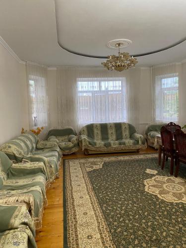 a living room with couches and a rug at Talas guest house in Talas