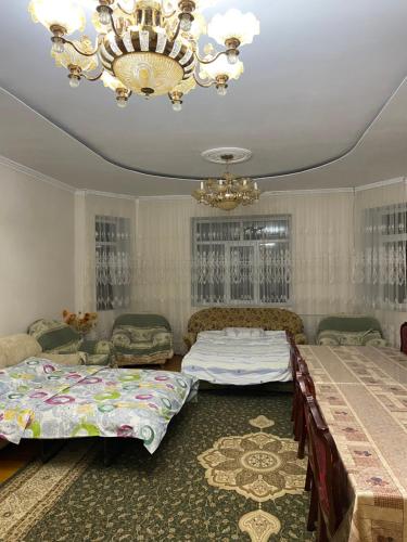 a bedroom with two beds and a chandelier at Talas guest house in Talas