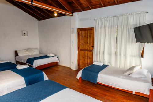 a bedroom with two beds and a television in it at Costa Beach in Zorritos