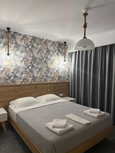 a bedroom with a bed with two towels on it at Lamda Deluxe Apartments in Keramoti