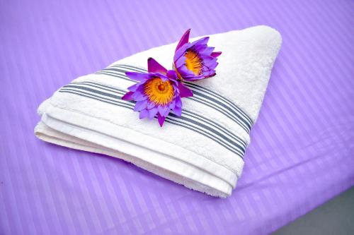 une serviette avec deux fleurs au-dessus dans l'établissement Arcadiaa Hotel, 