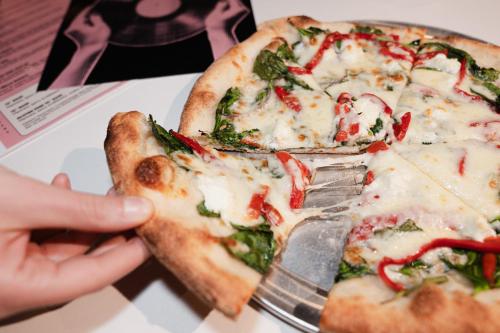 a person holding a slice of pizza with a fork at Hotel Ziggy On Sunset in Los Angeles