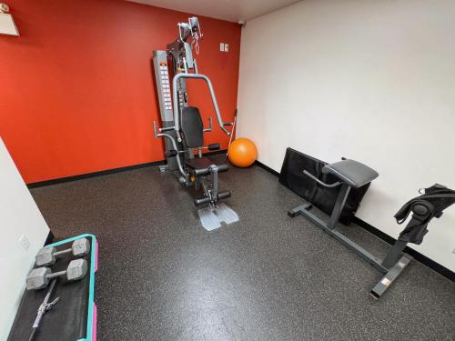 a room with a gym with a treadmill and weights at Ramada by Wyndham Sherwood Park in Sherwood Park