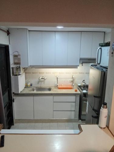 a kitchen with white cabinets and a sink and a refrigerator at Casa IWIN in Reyes