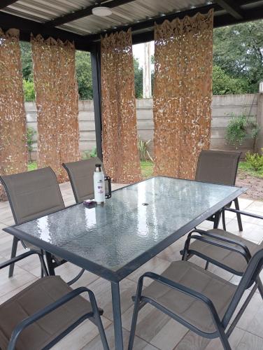a table and chairs on a patio with curtains at Casa IWIN in Reyes