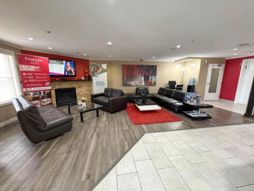 a large living room with couches and a fireplace at Ramada by Wyndham Sherwood Park in Sherwood Park