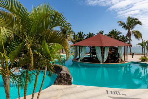 a resort pool with a gazebo and palm trees at Costa Beach in Zorritos