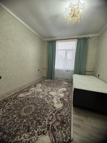 a bedroom with a chandelier and a large rug at Guesthouse Chon - Kemin in Shabdan