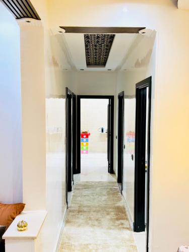 a hallway with black doors and white walls at Appartement avec piscine in Mohammedia