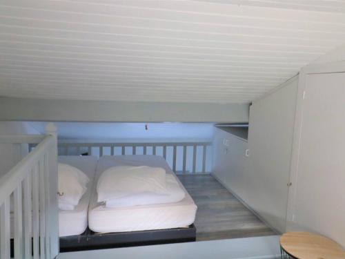 Cette chambre comprend un lit avec des draps et des oreillers blancs. dans l'établissement Maison avec Piscine et Activités, Proche La Palmyre - 4 Pers. - FR-1-738-9, aux Mathes