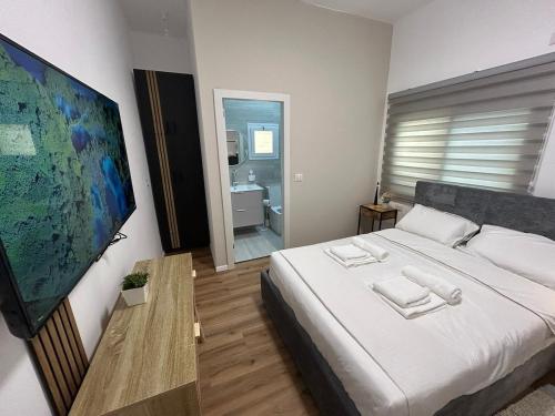 a bedroom with a large white bed and a bathroom at Eden apartment in Haifa