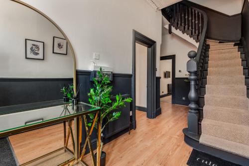 a hallway with a staircase and a glass table at The Rockfield by Serene Stays Stylish 6BR near Anfield with Bar Virgin Media and Fast WiFi in Liverpool