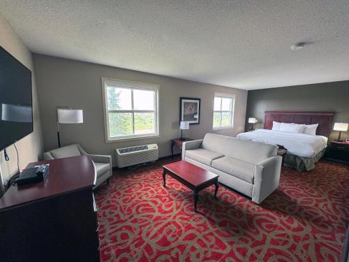 a hotel room with a bed and a couch at Ramada by Wyndham Sherwood Park in Sherwood Park