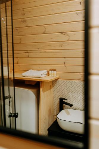 a bathroom with a toilet and a wooden wall at Chata Pod Lasem in Poręba