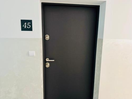 a black door with the number on it at Apartament Wiktoria Iława in Iława