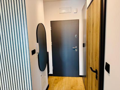 a room with a black door and a surfboard on the wall at Apartament Wiktoria Iława in Iława