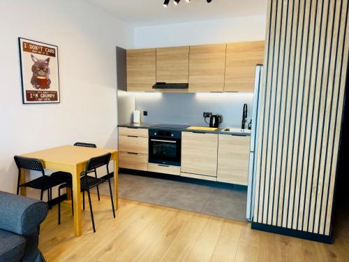 a kitchen with a table and a table and chairs at Apartament Wiktoria Iława in Iława