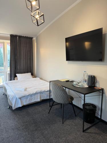 a hotel room with a bed and a table and a television at Aero Hotel in Chişinău