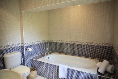 a bathroom with a bath tub and a toilet at A Peaceful Cotswolds Retreat in Bourton on the Water