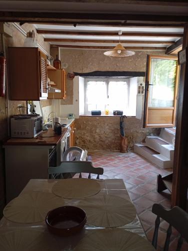 une cuisine et une salle à manger avec une table et des chaises dans l'établissement La chaise, à Saint-Aquilin