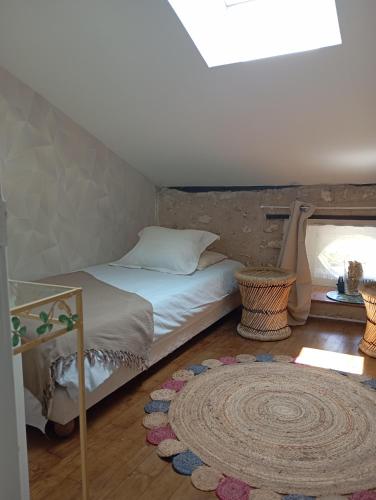 a bedroom with a bed and a rug on the floor at La chaise in Saint-Aquilin