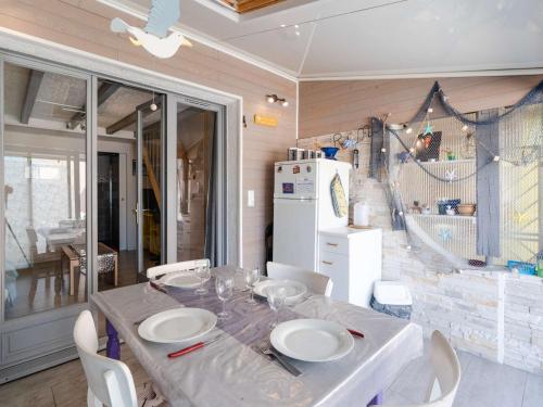 d'une salle à manger avec une table et un réfrigérateur blanc. dans l'établissement Charmant Pavillon Mezzanine Rénové à Gruissan, Proche Plage, 4 Pers, Animaux OK, Parking Gratuit - FR-1-409-197, à Gruissan
