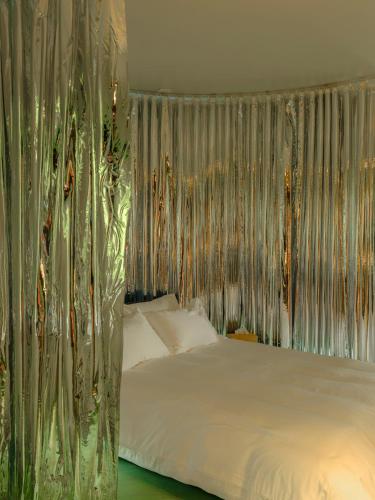 a bedroom with a bed with a canopy and curtains at BADANG Lab in Sainte-Anne-de-Beaupré