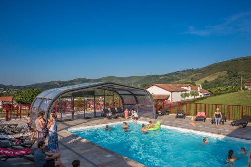 a group of people in a swimming pool at Domaine Chalets Larlapean in Saint-Martin-dʼArrossa