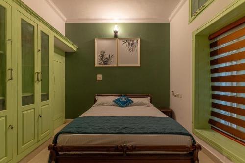 a bedroom with green walls and a bed at GEE DE Homes in Kizhake Chālakudi