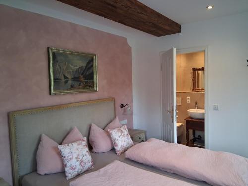 a bedroom with a bed with pink pillows on it at Die schlafende Goass in Bischofswiesen