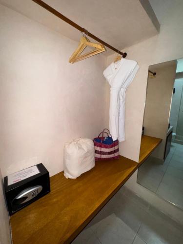 a room with a counter with a shelf with a shirt and bags at La Posada Hotel Boutique in Manzanillo