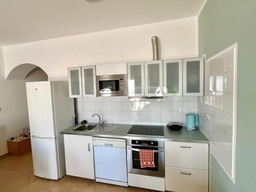 a kitchen with white cabinets and a white refrigerator at African Sunset in Sal Rei