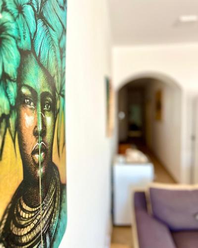 a painting of a woman on a wall in a room at African Sunset in Sal Rei
