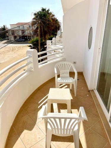 a row of white chairs and tables on a balcony at African Sunset in Sal Rei