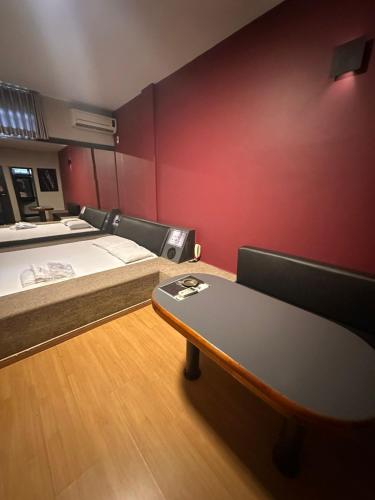 a room with two beds and a table in it at Motel Ibiza in Pará de Minas