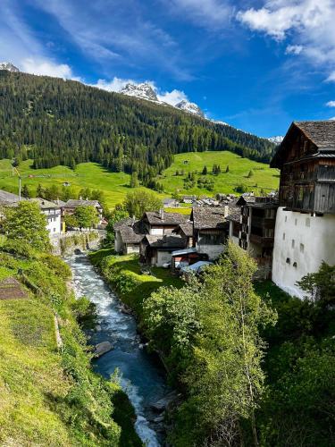 a village with a river and a mountain at Cosy studio apartment in Splügen in Splügen