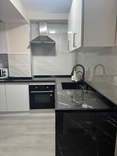 a kitchen with a black counter top and a sink at 2 bedroom apartment for rent in Cullera