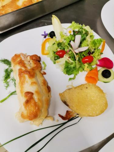 a white plate with food and a salad on it at Hotel Restaurant Rose des Pyrénées in Belvianes-et-Cavirac