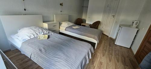 a hotel room with two beds and a refrigerator at Viršutinė 9 1 kambarys in Klaipėda
