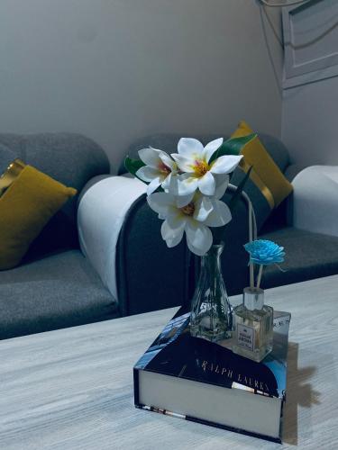 a vase with flowers on a book on a table at جناح ديلوكس غرفة وصالة في موقع مميز - مرخصة ضيافة خاصة - in Khamis Mushayt