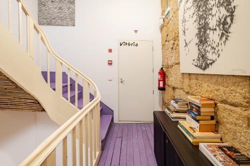 a hallway with stairs and books on a table at Belomonte 22 Apartments Porto World Heritage in Porto